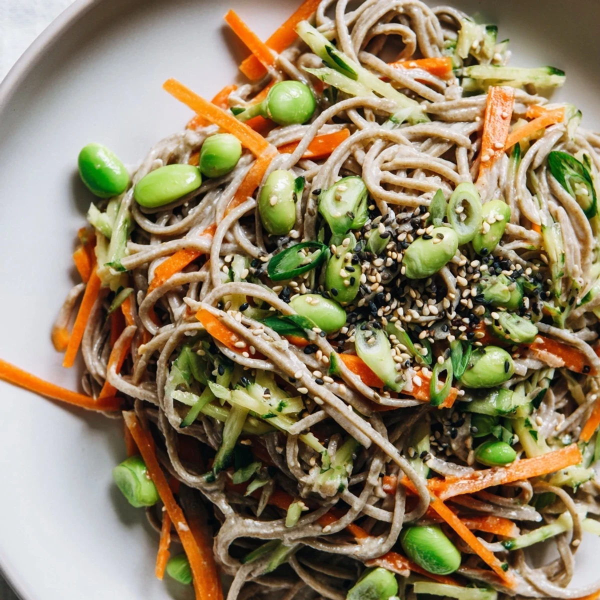 This Asian Sesame Noodle Salad, tossed beautifully, features sesame seeds sprinkled over fresh ingredients.