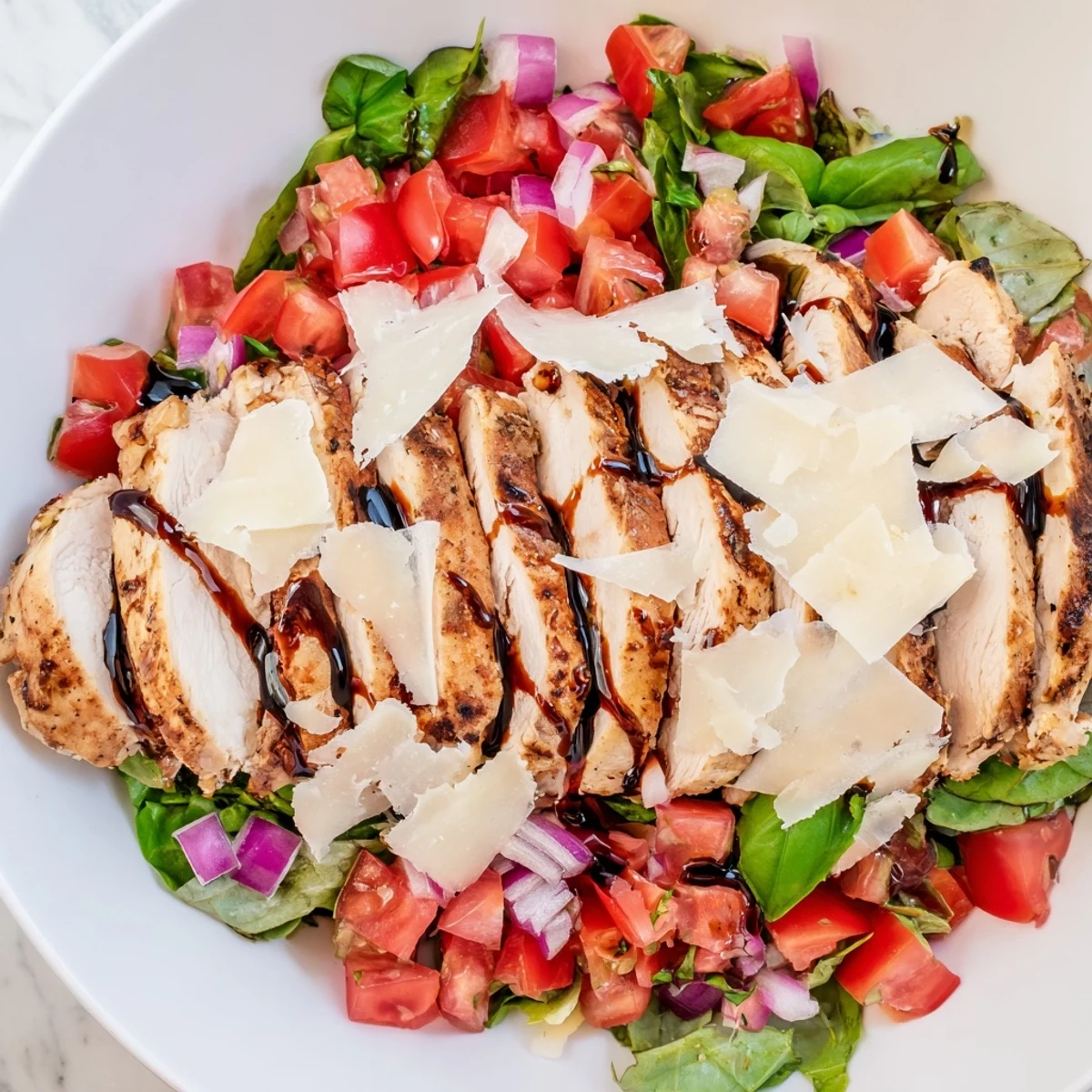 Grilled chicken slices topped with fresh tomato-basil bruschetta on mixed greens for a light Italian-American main dish.