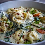 Gekochte Käsetortellini in cremiger Brühe mit Karotten und Zucchini für ein wohliges Abendessen