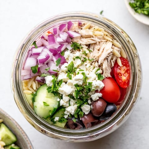 Layered Greek Pasta Chicken Salad Jars with orzo, chicken, and feta.