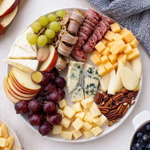 This Winter Wonderland Grazing Tray features colorful seasonal fruits and tempting cheese selections, ready to eat.