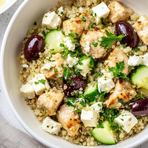 Frisch angerichtete Mediterranean Chicken Bowl mit oliven, Käse und einem zitronigen Oregano-Dressing.