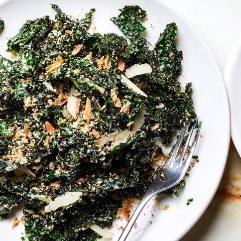 Massagede Kale-Salat mit Knoblauch-Parmesan-Sauce, gerösteten Krümeln und zarter Parmesan-Raspel.