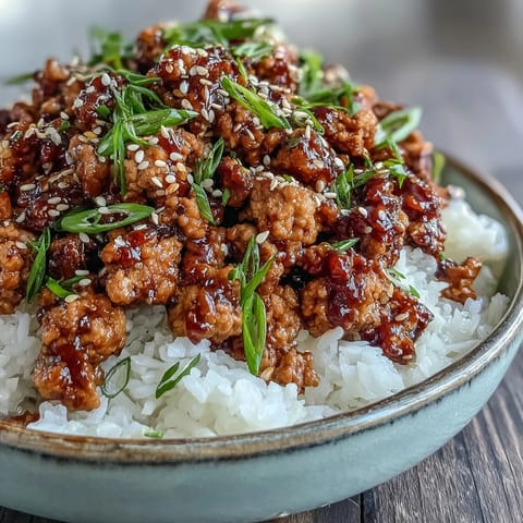 Geröstete Sesamsamen und gehackte Schnittlauchzwiebeln schmücken das Korean-Style Ground Turkey auf dem Teller.