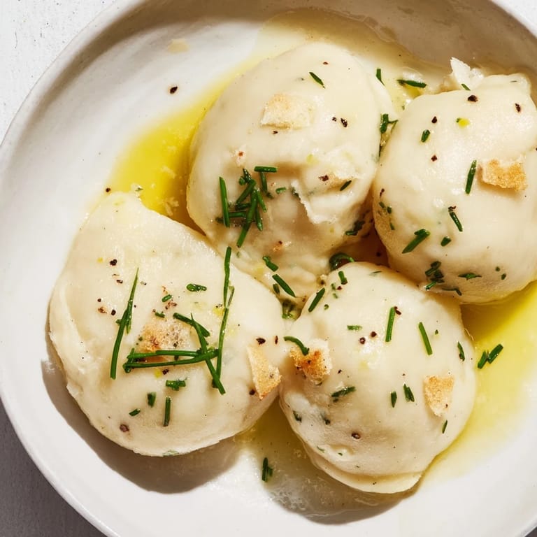 Savory potato dumplings, steaming and ready to eat, served with a fragrant truffle oil finish.