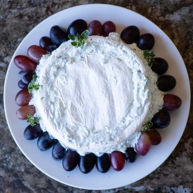 Enjoy this vibrant "Floating Island" plate: a cheese wheel "island" with grape garnishes.