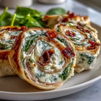 Zum Erstellen von drei einzigartigen, SEO-optimierten ALT-Texten für das Rezeptfoto "Turkey, Cheese & Spinach Tortilla Pinwheels" für US-amerikanische Food-Blogs: